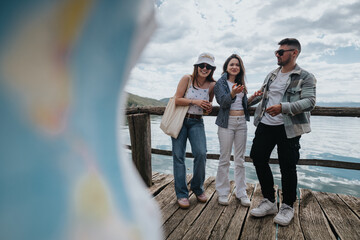 Poster - Three happy tourists standing on a wooden pier by the lake, sharing a moment on their travel getaway.