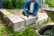 © artursfoto - Construction worker laying expanded clay blocks. Foundations of a house, the frame of a new house in the process of construction