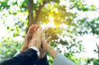 © wutzkoh - Group of volunteer people joining for cooperation about global community teamwork with join hand together, World environment day, sustainable development goal.