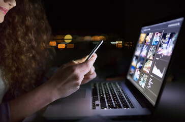 Wall Mural - Close up of university student is writing her thesis on a laptop at night, sitting at home at table, focusing on her research. Preparing for final exam, studying.