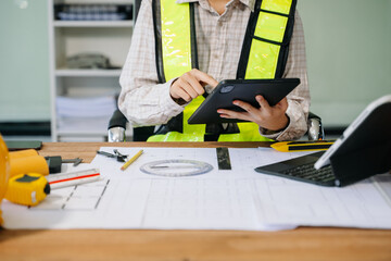 Wall Mural - businessman hand working and laptop with on on architectural project at construction site