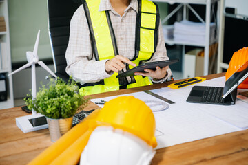 Wall Mural - businessman hand working and laptop with on on architectural project at construction site