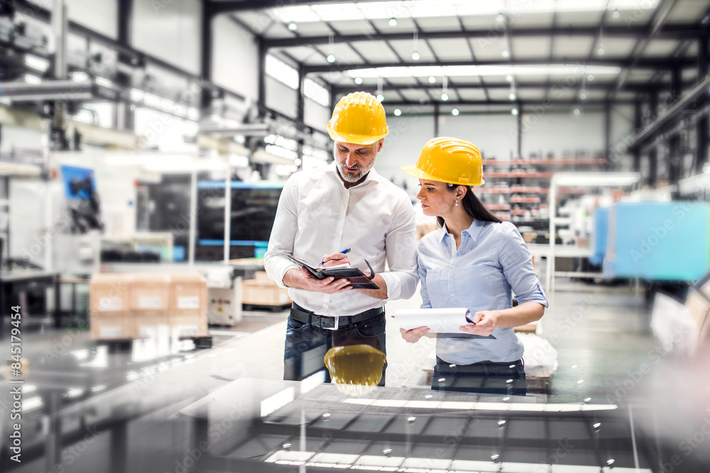 Factory Project Work Two project managers standing in modern industrial factory ...