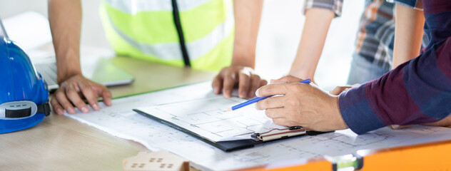 Wall Mural - Group of builder team planning and discussing construction home drawing.