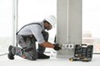 © Serhii - African American electrician replacing socket in room
