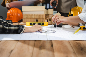 Wall Mural - Engineer teams meeting working together wear worker helmets hardhat on construction site in modern city.Asian industry professional team..