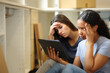 © Antonioguillem - Sad women checking tablet renovating house