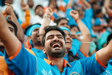 Cheerful Indian cricket enthusiasts in blue jerseys, expressing joy and unity during a game.