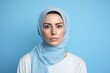 © Hanna Haradzetska - A sad woman, 35, Middle Eastern, dealing with health issues, on a pastel baby blue background