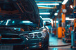 © Maule - A black car with an open hood in a brightly lit repair shop