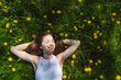 © Westend61 - Happy girl lying on yellow dandelions in park