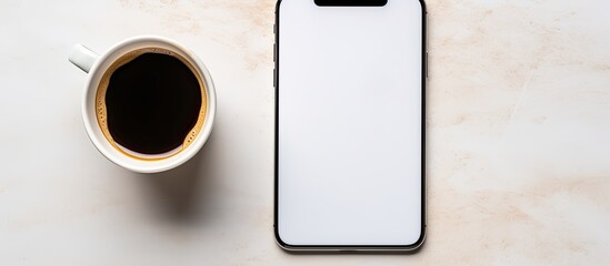 Fototapete - Top view of a smartphone coffee cup and notepad placed closely together in a visually appealing composition with ample copy space for images