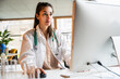 © Westend61 - Young female doctor working on computer at desk in office
