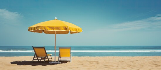 Aufkleber - A sunny beach with a scenic view of sand beach chairs and a yellow umbrella creating an ideal setting for relaxing with ample copy space image