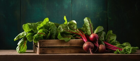 Copy space image of crate containing fresh homegrown beetroot with the leaves still intact The beetroot sourced locally showcases healthy plant based food and comes from a vintage wooden boards table