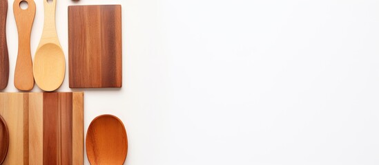 Poster - A top down view of cutting boards and wooden spatulas on a white background offering a copy space image and conveying the concept of culinary backgrounds