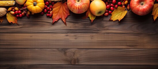 Aufkleber - Autumn maple leaves pumpkin apple corn and red berries beautifully arranged on a rustic wooden background creating a delightful Thanksgiving day copy space image