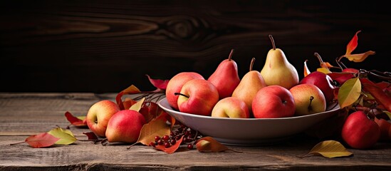 Wall Mural - On a wooden table a clay plate displays ripe pears and red paradise apples Fallen leaves scatter around the plate creating a picturesque scene Ample copy space is available for additional elements
