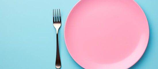 Aufkleber - Top view of a clean blue ceramic plate accompanied by a stainless knife and fork isolated on a pink background The cutlery is neatly organized ready for a delicious meal Copy space is available for y