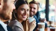 © Natalia - Group of cheerful colleagues enjoying coffee break at a cafe, with one smiling woman in focus holding a cup.