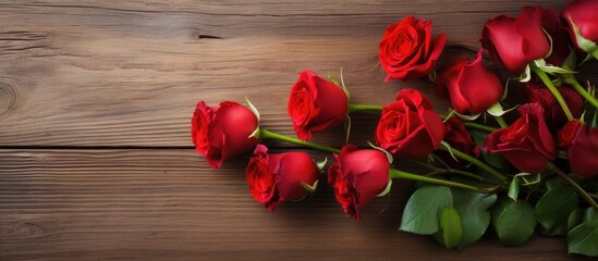 Leinwandbilder - A beautiful arrangement of bright red roses displayed against a rustic wooden background with plenty of empty space for additional elements in the image