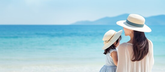 Sticker - Asian mother and child happily bond on a tropical beach enjoying a fun filled family vacation by the beautiful sea on a sunny summer day The mom and son are all smiles during their holiday Copy space