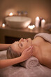 © Alexandra W/peopleimages.com - Face massage, spa and relax with woman, beauty and candles with hospitality and stress relief. Person, facial and girl with wellness or healthy with vacation or peace with holiday, detox or self care