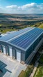© YURII Seleznov - Aerial view of a modern warehouse with solar panels on the roof an aerial drone photo.