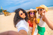© unai - Three women are posing for a picture on the beach
