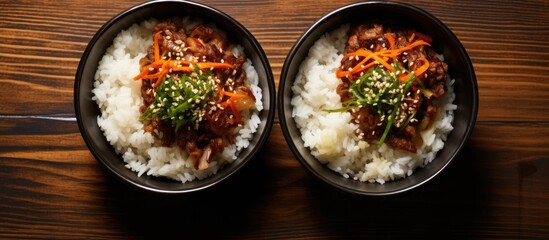 Wall Mural - A top down view of Korean beef and rice bowls placed on a wooden surface with ample copy space for adding text The image is presented in a flat lay style