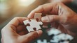 © Natawut - Closeup of hand holding white jigsaw piece, symbolizing collaboration and intelligence in people for mental development