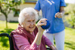 © Halfpoint - Female caregiver doing motorized exercises with senior woman in wheelchair. Nurse and elderly woman squeezing small, soft ball.
