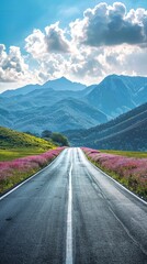 Canvas Print - Empty highway in the middle of blooming meadows, steep mountain peaks in the background, clear sunny day, bright rays, incredible nature