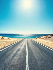 Wall Mural - Empty highway on the background of huge sand dunes and sea coast on one side of the road, blue water, clear sunny day, bright rays, incredible nature
