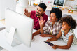 © NDABCREATIVITY - Happy african american family having fun together while using computer together at home