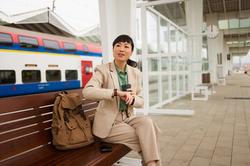 Asian businesswoman checking the time on her wristwatch at the train station