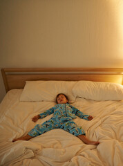 Sticker - Child, bed and rest for night, sleeping and tired with fatigue and peace. Boy, dreaming and exhausted with pyjamas, onesie and bedroom with lamp for serene childhood at home or house for calm kid