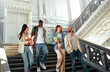 © Valerii Apetroaiei - College students bonding in a historic building stairwell on campus, creating a lively atmosphere