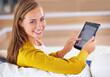 © peopleimages.com - Portrait, smile and woman with tablet in living room for relax, social media or communication in apartment. Happy, technology and face of female person for internet search, networking or news article