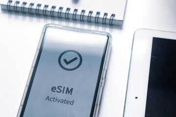 Advantage of eSIM connection for network services concept. A person's mobile phone displaying eSIM activated successfully.