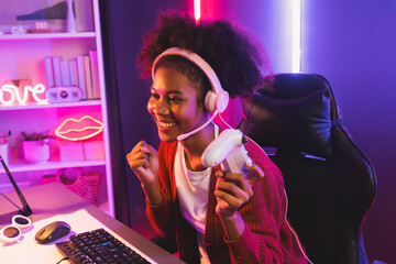 Wall Mural - Host channel of gaming streamer, African girl wining with Esport skilled team player and viewers online game in neon color lighting room. Concept of cybersport indoor activities. Tastemaker.