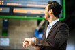 © Minerva Studio - Businessman checking time at train station