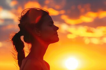 Woman silhouette breathing fresh air at warm sunrise.