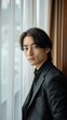 © Néstor - Japanese handsome man standing next to curtains in the room