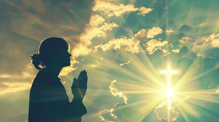 Wall Mural - A silhouette of a person praying to God in front of majestic clouds with a glowing cross