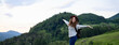 © Halfpoint - Young tourist woman traveller with backpack walking in nature. Active hiker on trail in mountains enjoying sunset. Banner with copy space.