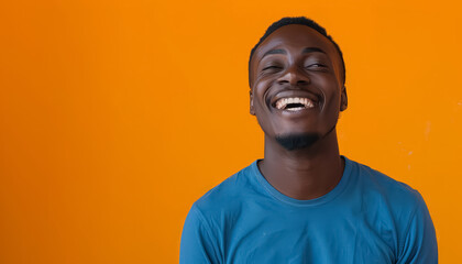 Wall Mural - A smiling man in a blue shirt is standing in front of a yellow wall