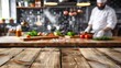 © abdul kahfi - Empty wooden table with blurred background of chef cooking in restaurant kitchen