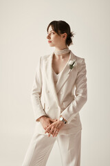 Wall Mural - A stunning young bride poses in a chic white blazer and pearl necklace, her elegant style captivating.