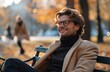 © olegganko - Man Smiling While Sitting on a Bench in a Park During Autumn